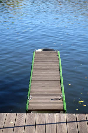Pier and mooring for small boats, going into the water, in a calm river close-up photoの写真素材