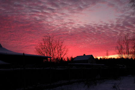 Beautiful rustic crimson sunset in a countryside setting in frosty winter eveningの写真素材