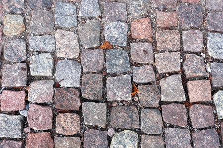 Old dark color paving cobblestone from rough blocks as background top view close upの写真素材