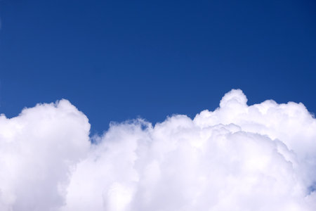 Beautiful calm sky landscape with white clouds on the bottom of photo and gradient blue sky above on bright sunny day horizontal viewの写真素材