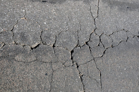 Asphalt surface of the roadway in bad condition needs repairs top view close upの写真素材
