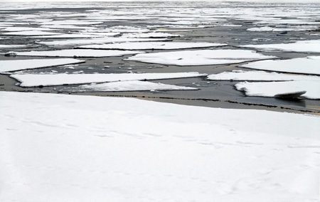 Landscape with melting broken ice floes floating on the river view till horizonの写真素材