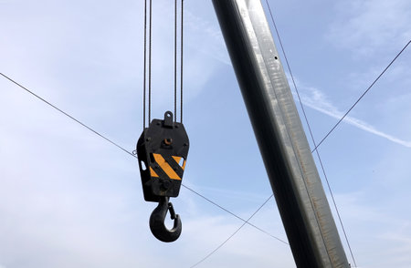 Big heavy with hook yellow stripes on metal cable on construction arm crane closeup viewの写真素材