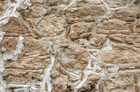 Vintage wall from old natural stones jointed with cement front view close upの写真素材