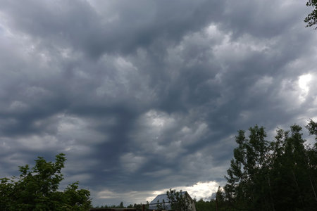 Heavy gray rainy cumulus clouds before the storm in countryside placeの写真素材