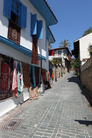 Going up by empty back street with handmade craft carpet shop in the tourist area in Antalya old city in heat dayの写真素材