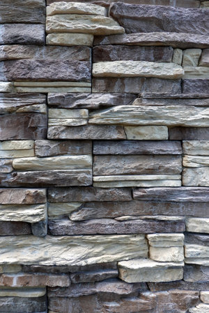 Wall stonework finishing from soft color natural stone trim as background front view close upの写真素材