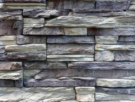 Wall stonework finishing from soft color natural stone trim as background front view close upの写真素材