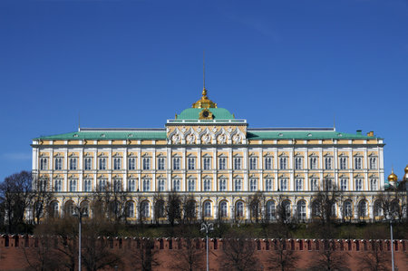 Moscow. Russia - April the 14th 2022: Grand Kremlin Palace with spire on cupola behinf red brick Kremlin wall cloudless sunny bright dayのeditorial素材