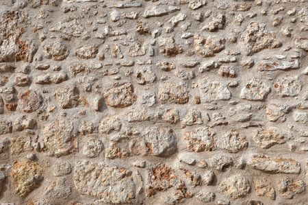Vintage wall from old natural stones jointed with cement front view close upの写真素材