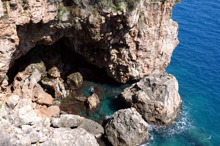 Top view to stone grotto and azure water surface on the sea with small waves on sunny dayの写真素材