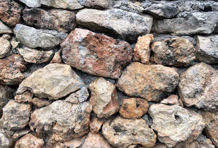 Old stonework wall from natural different size stones as background front view close upの写真素材