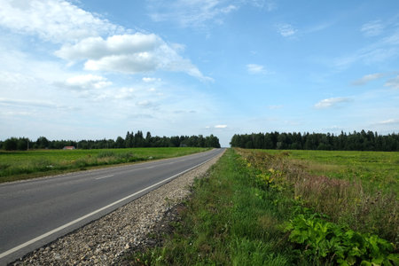 Empty rural asphalt road with road markings through the fields to the skylineの写真素材