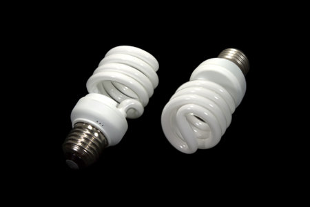 Two energy saving spiral bulbs isolated on black background studio shotの写真素材