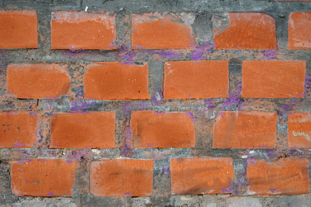 Red bricks in concrete wall with as background front view close up horizontal viewの写真素材
