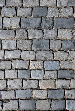 Dark gray cobblestone pavement from old smooth stones as background top view close upの写真素材