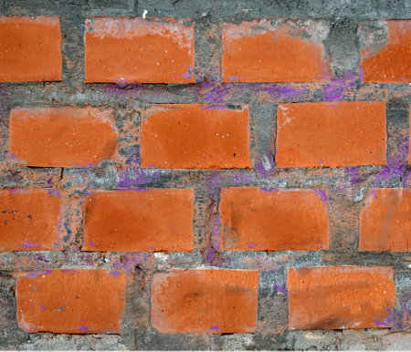 Red bricks in concrete wall as background front view close up horizontal viewの写真素材
