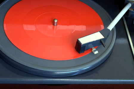 Old vintage record player with 7 inch flexible record on the disk top view close-up