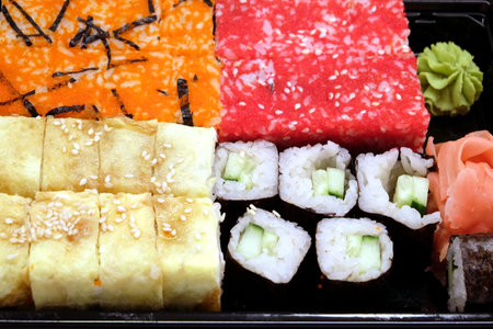 Appetizing fresh sushi pieces on black kitchen tray front view close upの写真素材