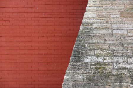 Old retro style red wall from brickwork combined diagonal with rough stone wall as background front view closeupの写真素材
