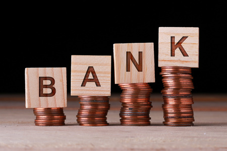 Bank text written on wooden block with stacked coins. Business and Financial concpet.の写真素材