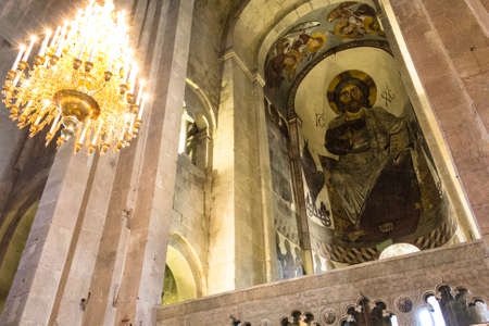 Sunlit painting of Jesus Christ on dome of Church with chandelier