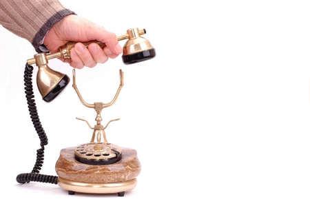 hand holding receiver of old telephone on white background