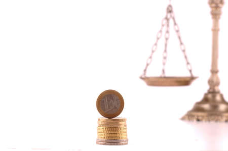 Euro coin and scales on white background, focus on the Euro coinの写真素材