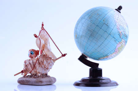 Model of sailboat made of shells and globe, travel concept