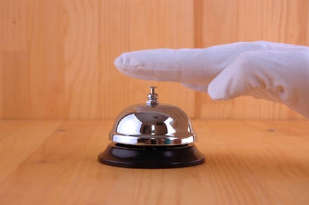 Hand in a white glove ringing the bell to call