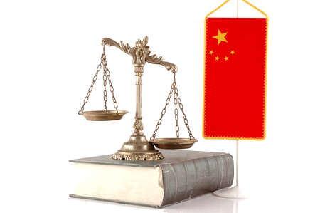 Decorative Scales of Justice on the book with Chinese flag on white  Law and order conceptの写真素材