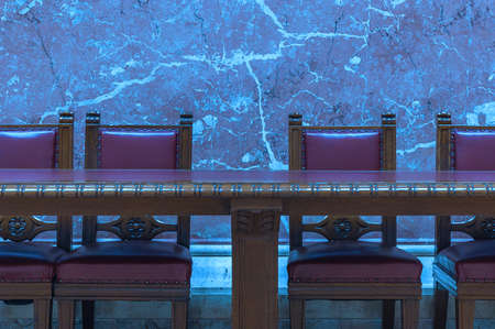 Red Vintage chairs by the old wooden conference table with a blue marble background wall.の写真素材