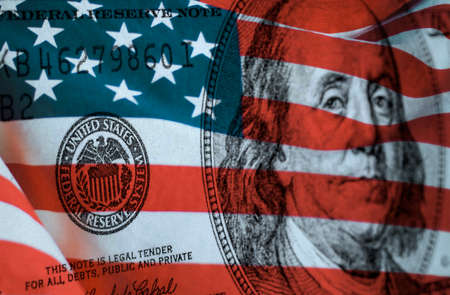 Federal reserve system symbol on hundred dollar bill with united states of america flagの写真素材
