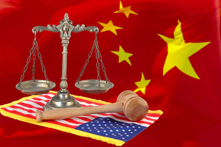 scales of justice and wooden gavel on the united states flag, chinese flag backgroundの写真素材
