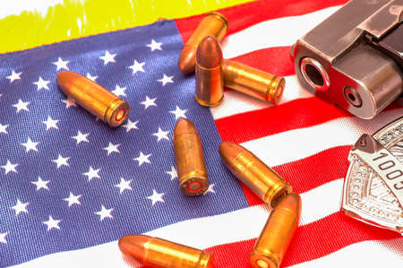 Police badge, gun and bullets on an American flag