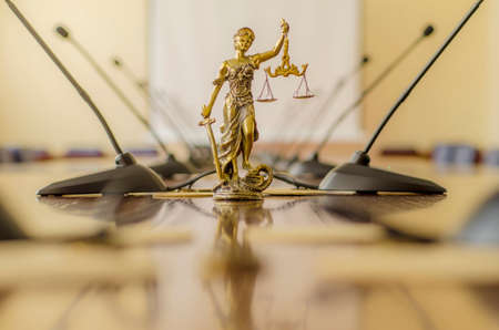 Statue of Lady Justice on the table with  microphones in th conference roomの写真素材