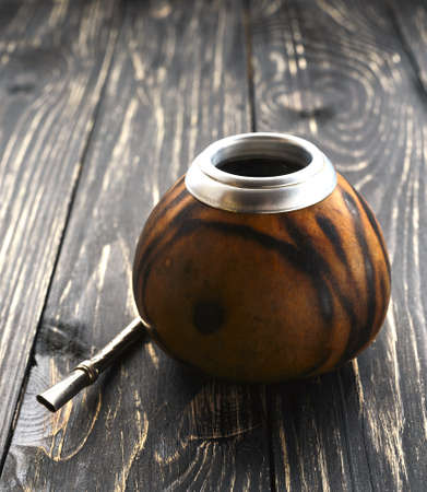 South American yerba mate tea in a wooden mate calabash at rustic tableの写真素材