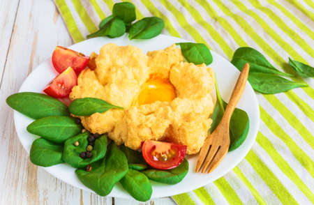Baked Eggs Orsini with spinach and cherry tomatoes. Traditional French breakfast. European cuisineの写真素材