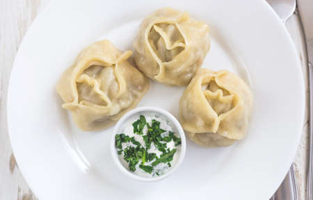 Plate of traditional Turkish manti with sour cream sauce and cilantro. Lunchの写真素材