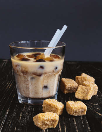 Milk with ice coffee and cane sugar on rustic background. Refreshment.の写真素材