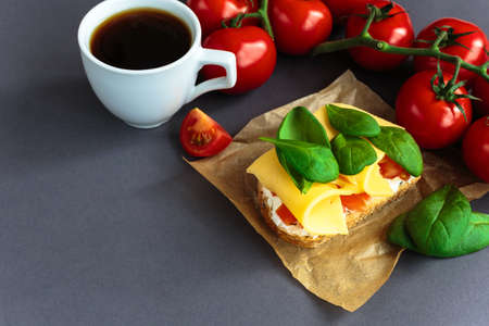 Bruschetta with spinach, cheese and cherry tomatoes on slices of toasted baguette or ciabatta and cup of coffee. Traditional Italian appetizers. European cuisine.の写真素材