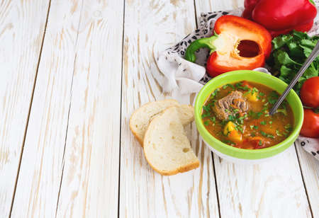 Caucasian lamb or beef Shurpa soup with vegetables at wooden table. Closeup.の写真素材