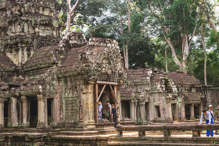 Ta Prohm, Siem Reap, Cambodia - December 7, 2016: Huge trees, galleries and walking tourists at sunny morning.のeditorial素材