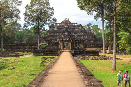Angkor Thom, Baphuon Temple, Siem Reap, Cambodia - December 7, 2016: Tower and galleries and walking tourists at sunny morning.のeditorial素材