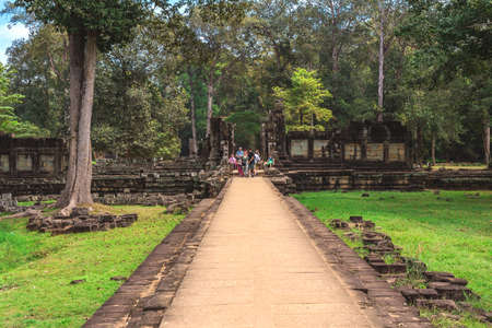 Angkor Thom, Baphuon Temple, Siem Reap, Cambodia - December 7, 2016: Tower and galleries and walking tourists at sunny morning.のeditorial素材