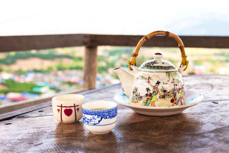 Chinese style teacup and teapot with green tea on table with balcony view on Santichon Chinese...