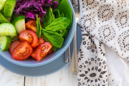 Green vegetable salad with  tomato, red cabbage, cucumber and spinach. Selective focus. Closeup.の写真素材
