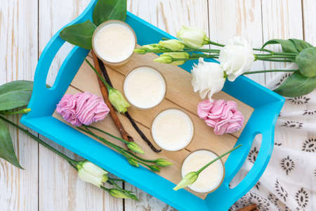 Traditional Homemade Eggnog with cinnamon and vanilla, marshmallow dessert and white eustoma flowers. Spring and easter conceptの写真素材