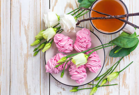 Homemade marshmallow dessert, cup of hot tea, vanilla sticks and white eustoma flowers. Spring conceptの写真素材