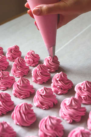 Raws of homemade strawberry marshmallow dessert making with cream injector. Fabrication process.の写真素材